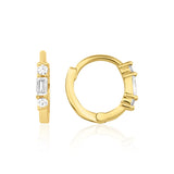 yellow gold huggie hoop earrings with a baguette-cut and round clear stones on white background