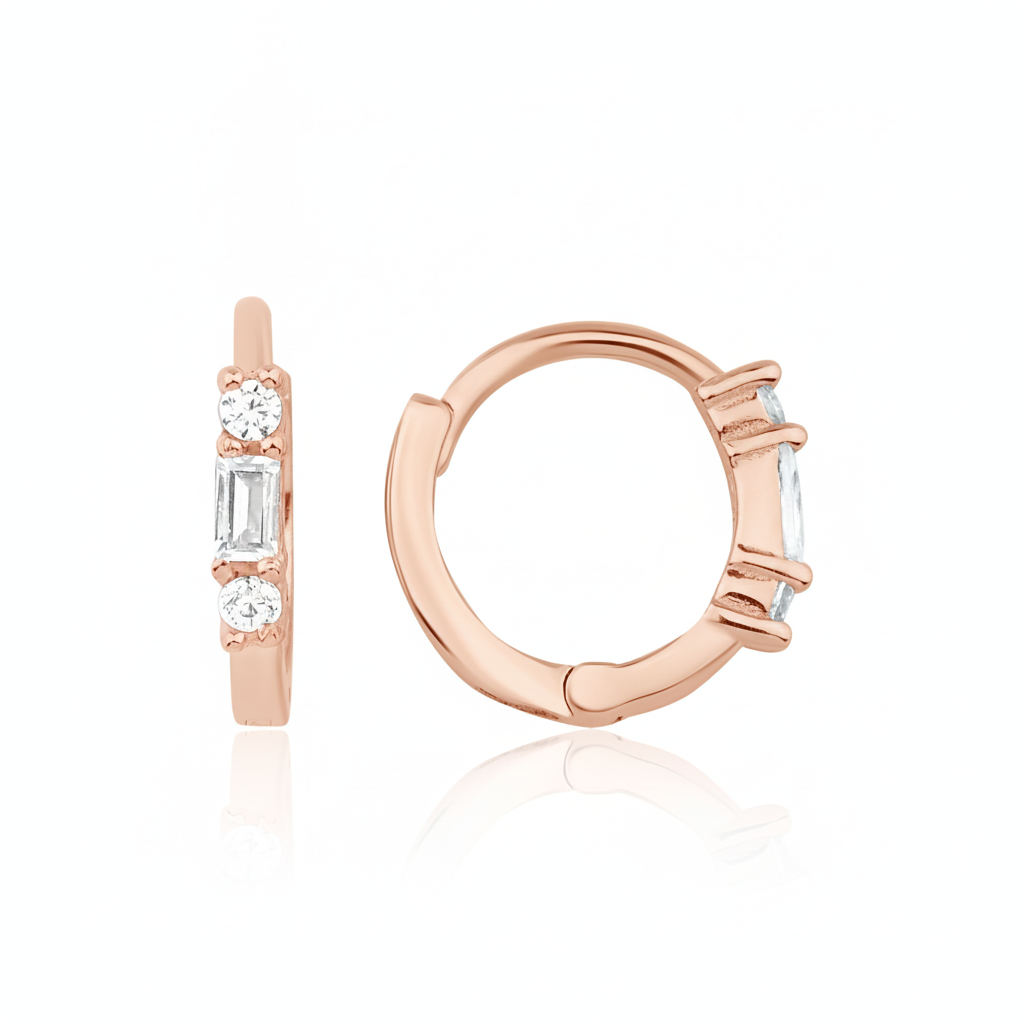 rose gold huggie hoop earrings with a baguette-cut and round clear stones on white background