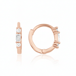 rose gold huggie hoop earrings with a baguette-cut and round clear stones on white background