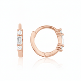 rose gold huggie hoop earrings with a baguette-cut and round clear stones on white background