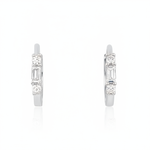 white gold huggie hoop earrings with a baguette-cut and round clear stones on white background