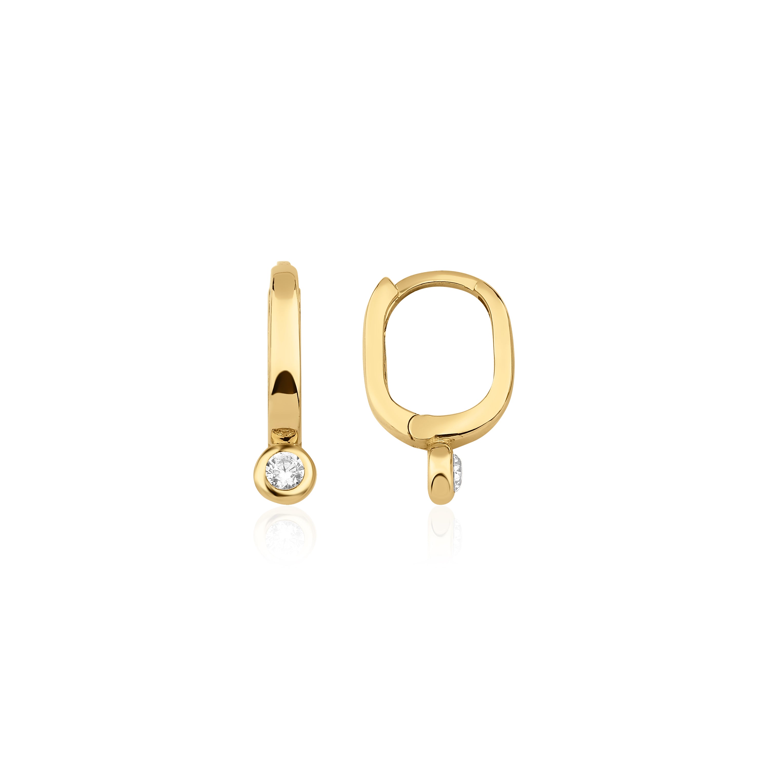 yellow gold oval huggie earrings with a bezel-set clear stone on white background