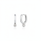 white gold oval huggie earrings with a bezel-set clear stone on white background