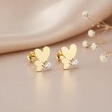 gold butterfly wing stud earrings with a clear stone accent, styled with dried baby's breath flowers on a blush background