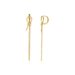 yellow gold knot huggie hoop earrings with drop chains on white background