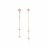 rose gold asymmetrical starburst drop earrings on white background