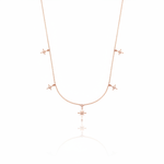 rose gold starburst charm necklace with compass star pendant on white background