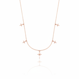 rose gold starburst charm necklace with compass star pendant on white background