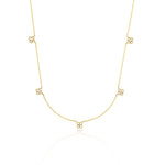 yellow gold four-petal flower station necklace on white background