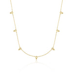 yellow gold beaded station necklace on white background