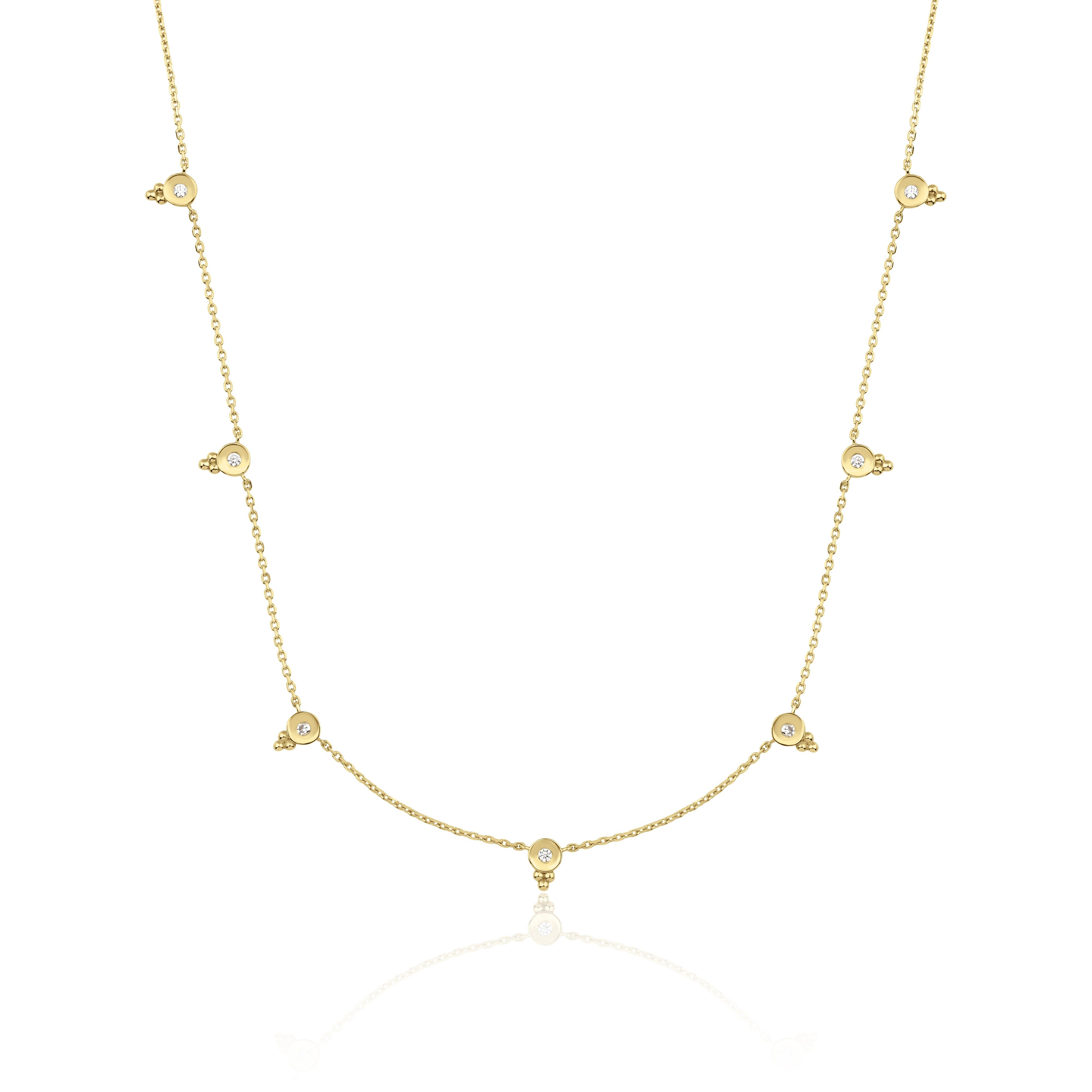 yellow gold beaded station necklace on white background
