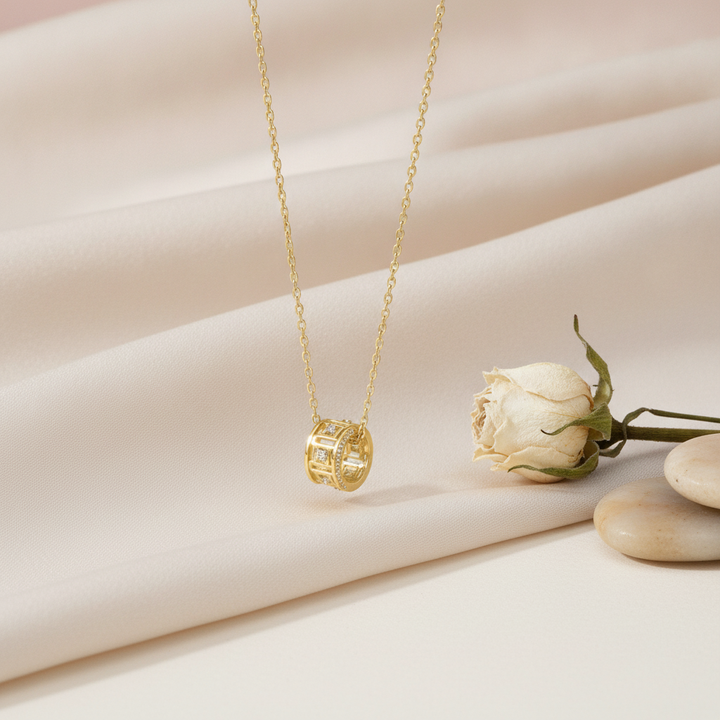 gold barrel pendant necklace styled with a dried white rose on a cream background