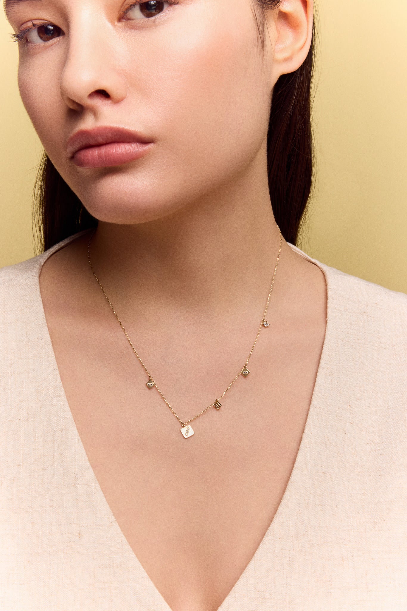 model wearing the gold square charm necklace