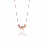 rose gold sunburst pendant necklace on white background
