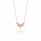 rose gold sunburst pendant necklace on white background