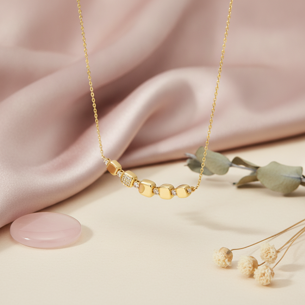gold cushion curve necklace styled with eucalyptus and dried flowers on a blush background