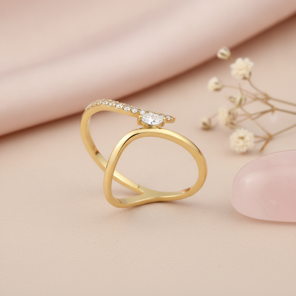gold bypass ring with a marquise stone styled with dried flowers on a blush background