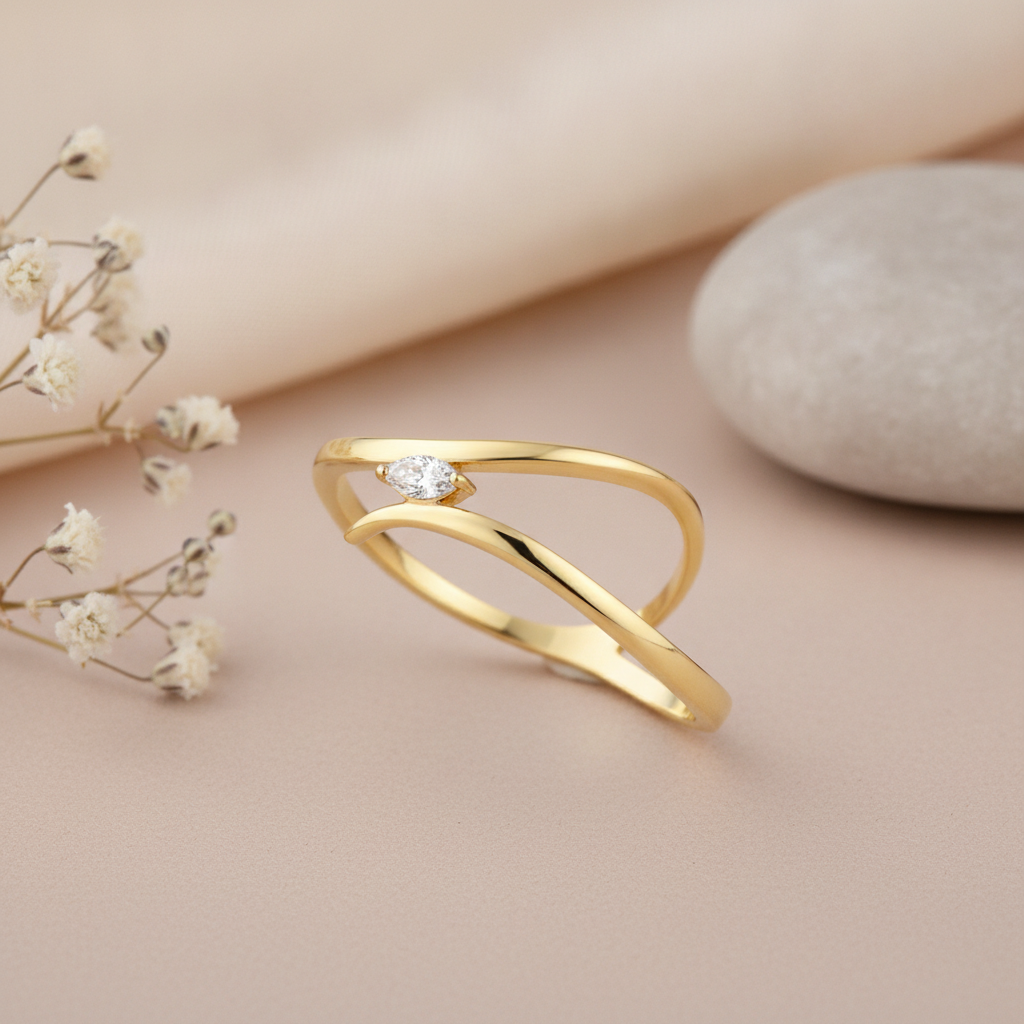 gold open crest ring with a marquise stone styled with dried flowers on a blush background