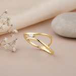 gold open crest ring with a marquise stone styled with dried flowers on a blush background