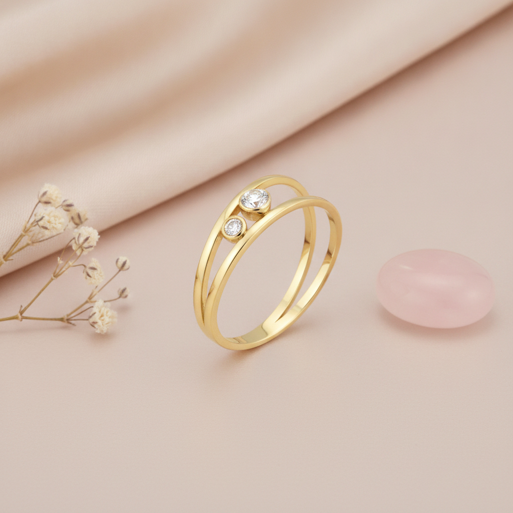 open double-band gold ring with two bezel-set clear stones, styled with dried baby's breath and a pink stone on a blush background
