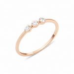 rose gold slim ring with three bezel-set White CZ stones in a row on white background