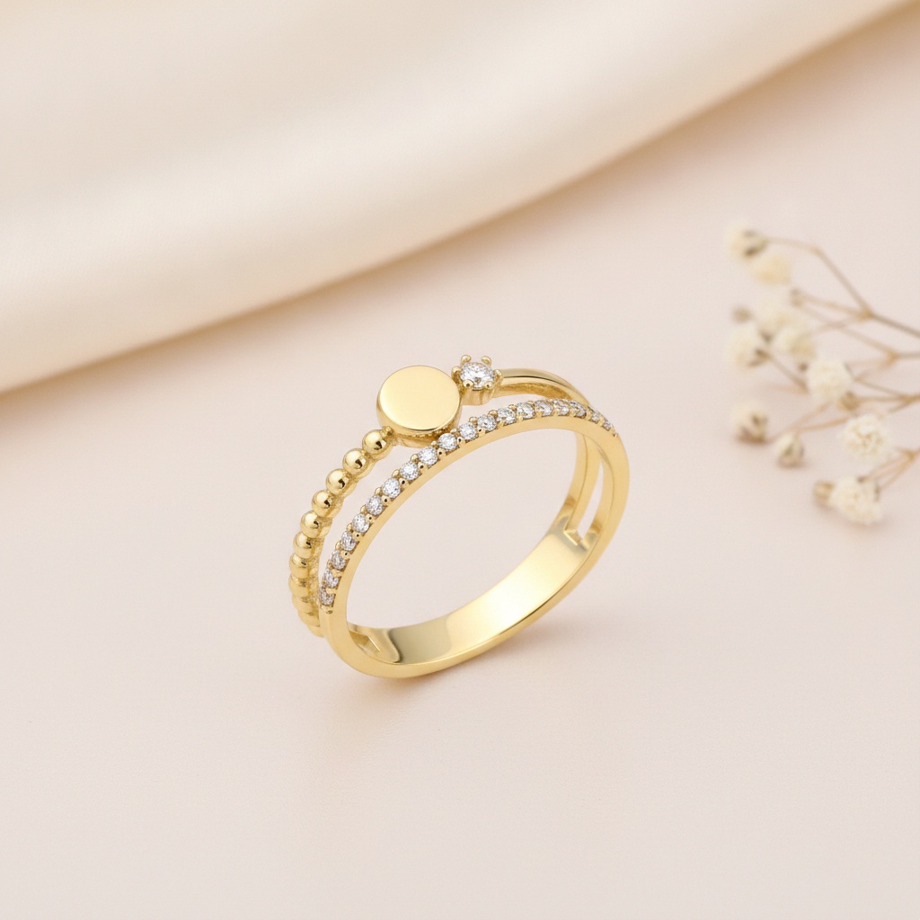 double-band gold ring with pave stones, a beaded band, and a polished gold sphere, styled with dried flowers on a blush background