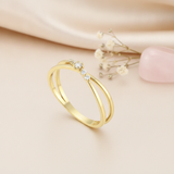 double-band gold ring crowned with five graduated White CZ stones, styled with baby's breath on a blush background