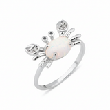 white gold crab ring with an iridescent white stone and clear accents on white background