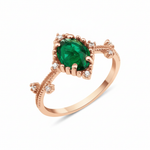 rose gold ring with an oval green stone and White CZ accents on a beaded band on white background