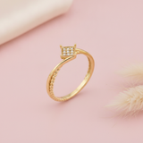 gold ring with a square pave crest and a twisted rope band, styled with a dried grass sprig on a blush background