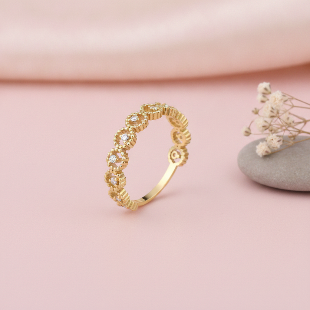 gold ring with linked beaded crowns and White CZ stones, styled with dried flowers on a blush background