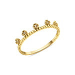 yellow gold ring with floral crests set with clear stones on a beaded band on white background