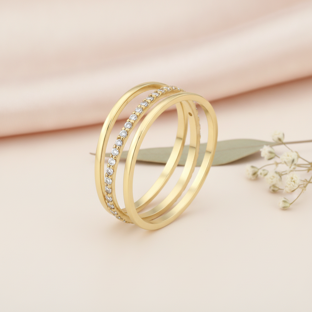 wide gold ring with sweeping beaded and pave rows, on pink fabric with dried flowers and a pink stone