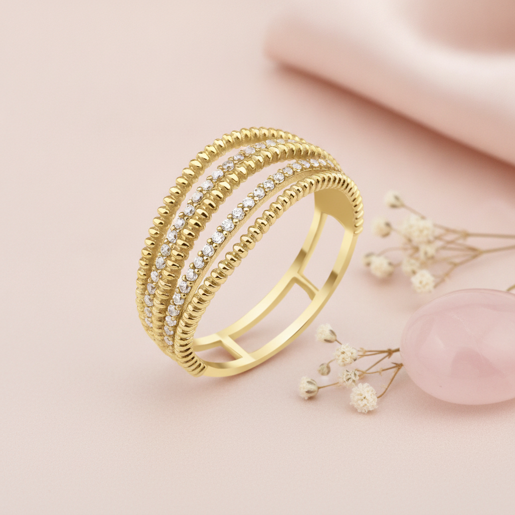 wide gold ring with a floral-like cluster of pave stones and beaded open-back band, on cream fabric with dried flowers