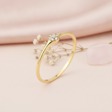 gold cluster ring with a round pave of White CZ stones on blush pink silk with dried baby's breath