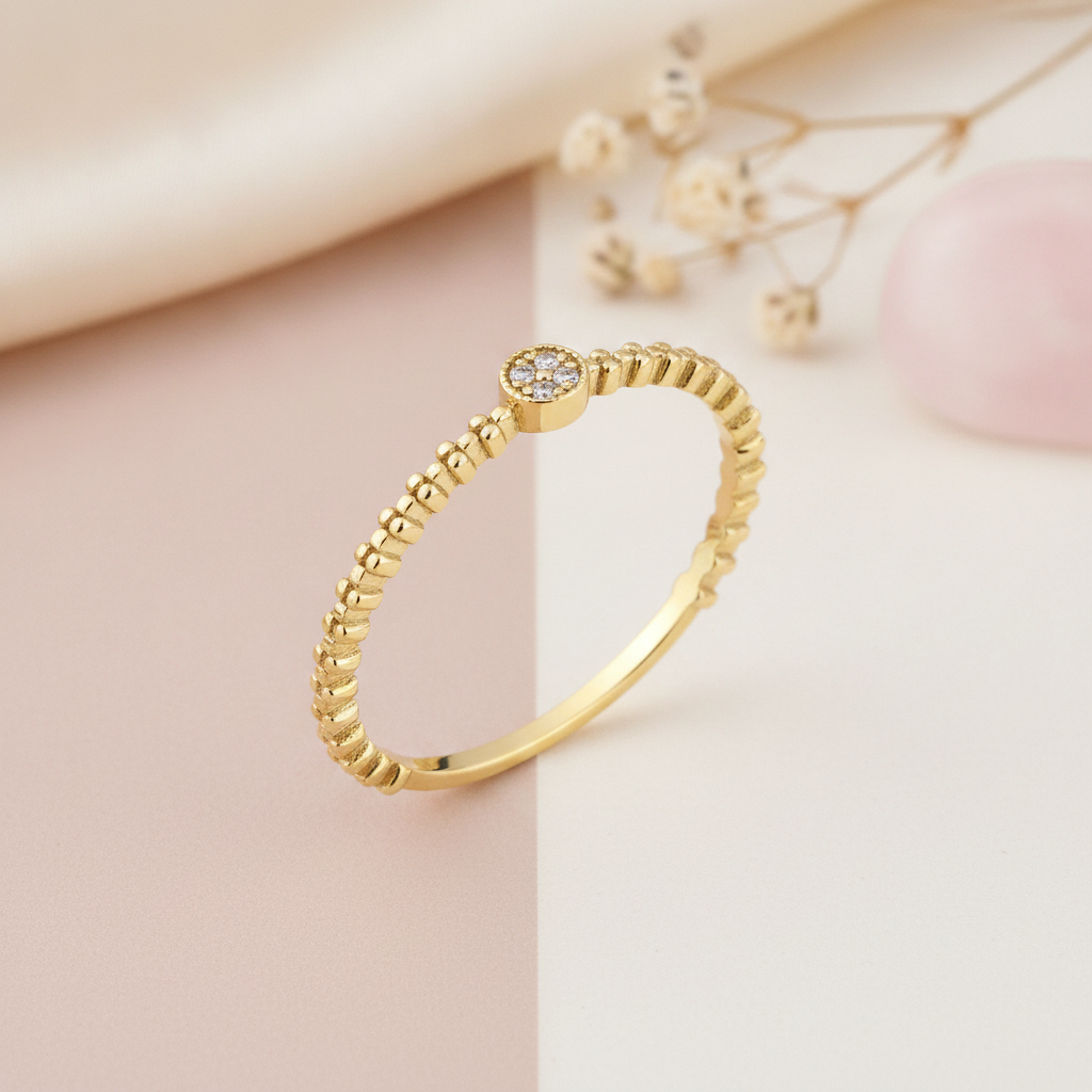 textured gold beaded band ring with a round stone cluster on a two-tone blush and cream background with dried flowers