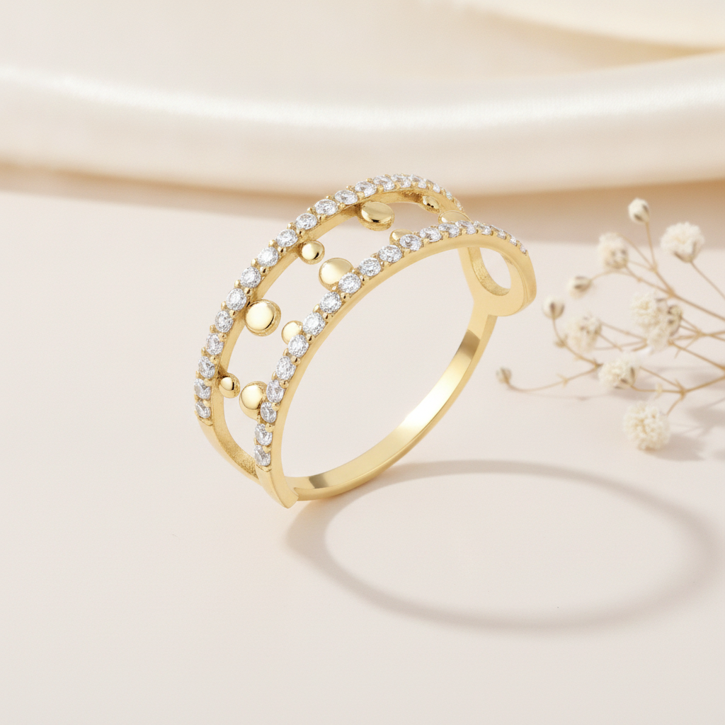 openwork gold ring with two pave rows and gold sphere accents on cream fabric with dried flowers