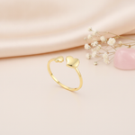 open gold ring with two smooth heart shapes on pink silk with dried flowers and a rose quartz stone