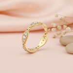 undulating gold ring with milgrain-beaded marquise stations and clear stones on cream silk with dried flowers