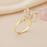 gold ring with four asymmetrical bezel-set clear stones on a polished band on blush silk with dried flowers and rose quartz