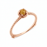 rose gold beaded ring with a golden-yellow stone on white background