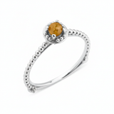 white gold beaded ring with a golden-yellow stone on white background