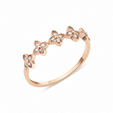 rose gold ring with four-petal flower motifs on white background