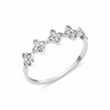 white gold ring with four-petal flower motifs on white background