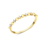 yellow gold ring with alternating beads and stones on white background