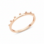 rose gold ring with raised golden spheres along the edge on white background