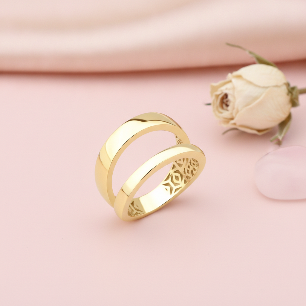 gold double-band ring with an open silhouette, styled with a dried rose and a pink stone on a pink background