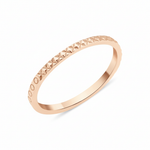 rose gold ring with carved circle and cross texture on white background