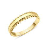 yellow gold ring with a beaded ribbon texture on white background