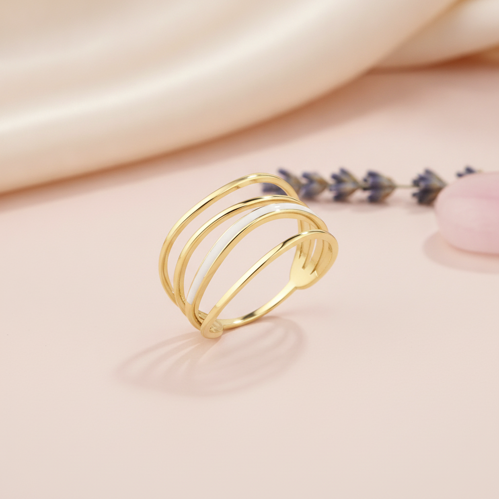 gold multi-band Linea ring with white inlay on a blush pink background with draped satin fabric and lavender sprigs